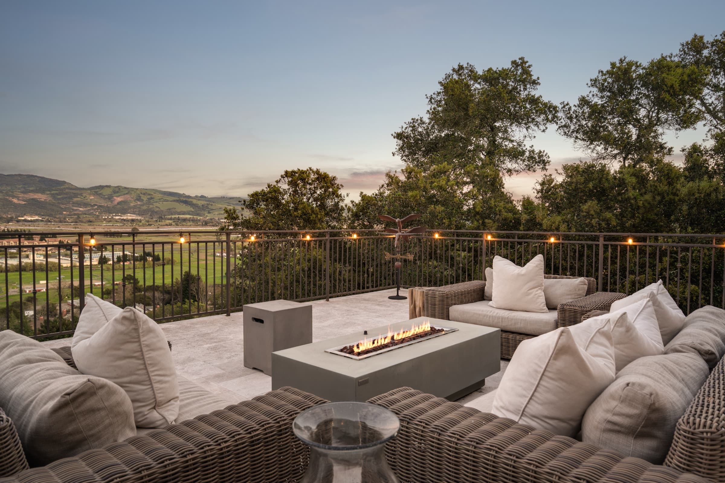 The deck lounge at twilight, with the valley lights beyond.